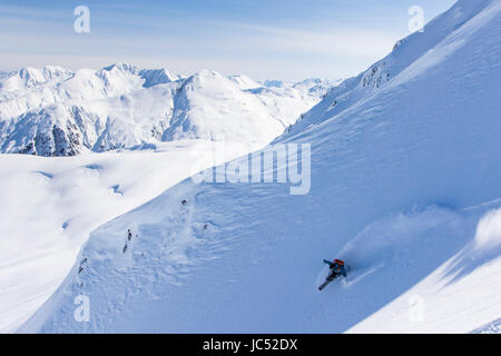 Snowboarder professionnel Robin Van Gyn, manèges de poudreuse sur une journée ensoleillée tout en snowboard à Haines, Alaska. Banque D'Images