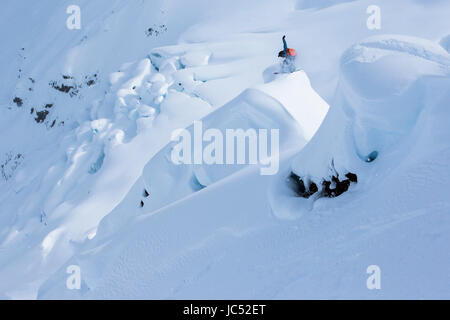 Snowboarder professionnel Robin Van Gyn, les prises et l'air s'empare de son administration sur une journée ensoleillée tout en snowboard à Haines, Alaska. Banque D'Images