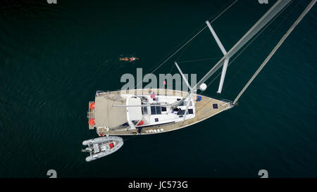 Vue aérienne d'un bateau à voile sur le lac de Genève, d'un zodiac attaché à la voile et d'un nageur solitaire en haut de l'image, dans le Canton de Vaud, Suisse Banque D'Images