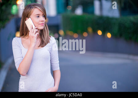 Young businesswoman having a conversation à l'aide d'un smartphone sur un appel téléphonique Banque D'Images