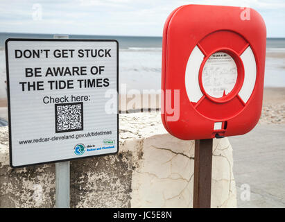 Avis d'avertissement avec code QR sur les horaires des marées et la ceinture de sauvetage sur la promenade de Saltburn by the Sea, Angleterre, Royaume-Uni Banque D'Images