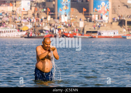 Un homme, Pilgrim, prend des bains et prier sur le bancs de sable à la sainte gange, panorama de Ghat Dashashwamedh, Main Ghat, dans la distance Banque D'Images