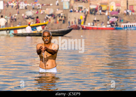 Un homme, Pilgrim, prend des bains et prier sur le bancs de sable à la sainte gange, panorama de Ghat Dashashwamedh, Main Ghat, dans la distance Banque D'Images