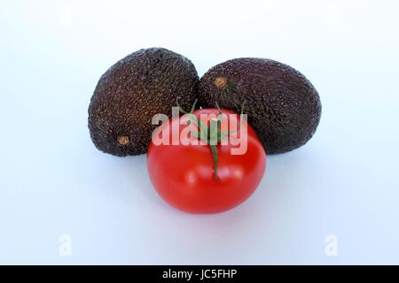 Une tomate accompagné d'avocat frais sur un fond blanc Banque D'Images