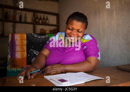 Une femme propriétaire de petite entreprise faisant quelques tenue de livres, Tanzania, Africa Banque D'Images