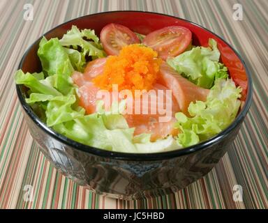 La cuisine japonaise, garniture de riz cuit à la vapeur avec du saumon frais, TOMATES ET LAITUE dans bol Donburi. Banque D'Images