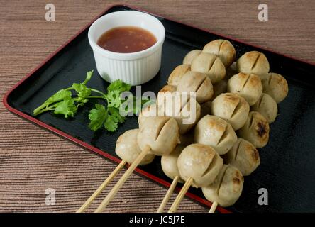 L'alimentation et de déguster une cuisine traditionnelle, des grillades sur brochette de boulettes de bois servi avec sauce épicée. Banque D'Images