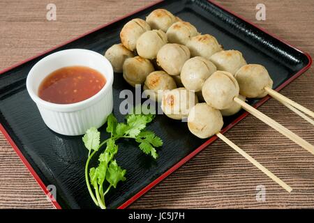 L'alimentation et de déguster une cuisine traditionnelle, des grillades sur brochette de boulettes de bois sucré servi avec sauce épicée et coriandre verte. Banque D'Images