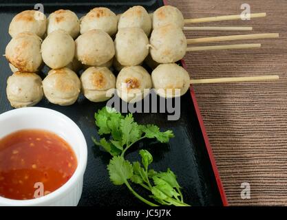 L'alimentation et de déguster une cuisine traditionnelle, des grillades sur brochette de boulettes de bois servi avec sauce épicée et coriandre verte. Banque D'Images