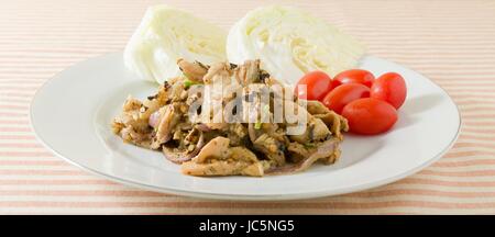 La cuisine thaï et de l'alimentation, Nam Tok traditionnel Thaï ou Moo Porc grillé épicé servi avec salade de choux et de tomates cerises. Banque D'Images