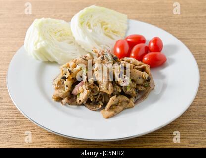 La cuisine thaï et de l'alimentation, Moo traditionnel Thaï Nam Tok ou salade de porc épicé servi avec du chou et tomates cerises. Banque D'Images