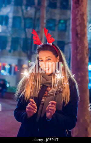 Young smiling girl holding sparkler dans sa main. Libre de fille avec Sparkle Banque D'Images