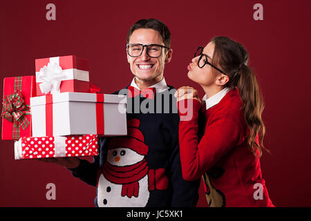 Nerdy woman kissing son petit ami dans le temps de Noël Banque D'Images