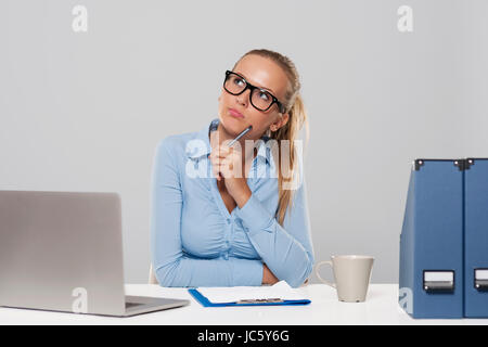 Thoughtful businesswoman sitting at office Banque D'Images