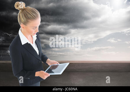 Image composite de blond businesswoman holding new tablet Banque D'Images