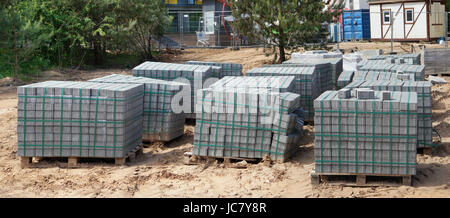 Des tas de nouvelles dalles de béton sur des palettes en bois. La construction du nouveau parking automobile sans nom dans le bois. L'argile jaune sol sablonneux. Panora Banque D'Images