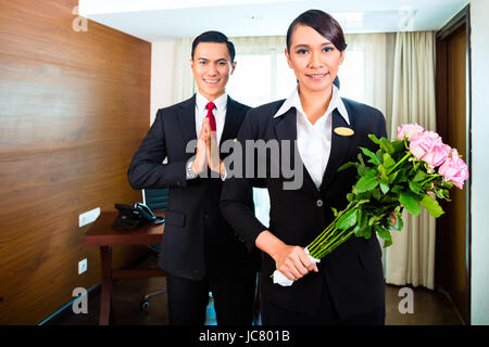 Portrait d'accueil personnel de l'hôtel avec des fleurs Banque D'Images