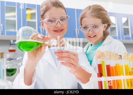 Des profils scientifique et fille dans le mélange des lunettes en tubes réactifs de laboratoire en Banque D'Images