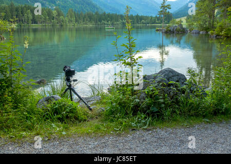 L'Allemagne. La forêt de montagne lac Hintersee. Temps couvert d'été. Les touristes sur les bateaux. Appareil photo sur un trépied au bord de l'eau Banque D'Images