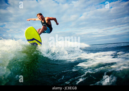 Surfer sur l'homme à cheval des vagues de la mer Banque D'Images