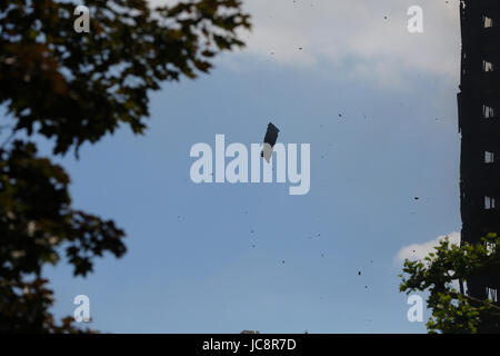 Londres, Royaume-Uni. 14 Juin, 2017. Les débris de la burnted bâtiment. La fumée s'élève de Grenfell Tower après un incendie a ravagé le bloc dans l'ouest de Londres. Le violent incendie a dévasté l'immeuble de 24 étages dans les premières heures de mercredi, les résidents de piégeage à l'intérieur comme les pompiers ont combattu l'incendie 200. Les services de police et d'incendie a tenté d'évacuer le bloc de béton et dit "sur un certain nombre de personnes sont traitées pour un éventail de lésions, y compris au moins deux pour l'inhalation de fumée. Credit : Dinendra Haria/Alamy Live News Banque D'Images