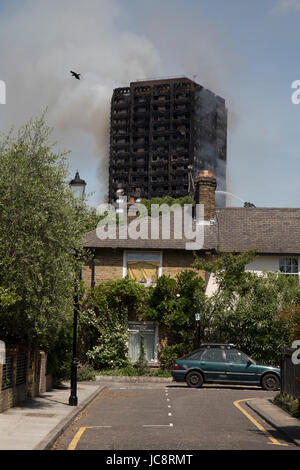 Londres, Royaume-Uni. 14 Juin, 2017. Le service des incendies d'urgence s'attaquer à un blaze à tour de Grenfell, près de Notting Hill le 14 juin 2017 dans l'ouest de Londres, Royaume-Uni. L'énorme incendie a ravagé la tour, piégeant de nombreuses personnes dans leurs foyers. Un certain nombre de décès sont signalés. Le bloc d'appartements dans le quartier de Kensington et Chelsea, panaches de fumée jaillit grand chemin au-dessus de la capitale après l'incendie a éclaté dans les premières heures du mercredi matin. Crédit : Michael Kemp/Alamy Live News Banque D'Images