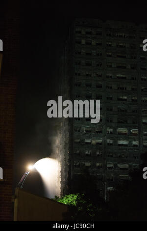 Londres, Royaume-Uni. 15 Juin, 2017. Les pompiers de l'eau sur un feu qui couve encore au tour de Grenfell, vers 13h00. Credit : Mark Kerrison/Alamy Live News Banque D'Images