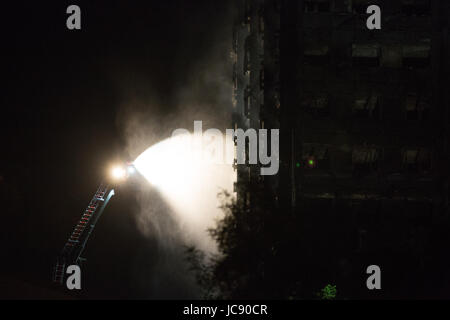 Londres, Royaume-Uni. 15 Juin, 2017. Les pompiers de l'eau sur un feu qui couve encore au tour de Grenfell, vers 13h00. Credit : Mark Kerrison/Alamy Live News Banque D'Images