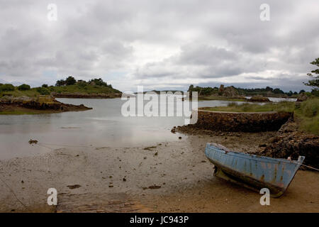 D'entrée d'un quartier calme sur la côte orientale de l'Île-de-Bréhat, Côtes-d'Armor, Bretagne, France, avec un vieux bateau de pêche dans l'avant-plan Banque D'Images