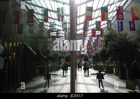 Enfant est exécuté de façon ludique le long du corridor dans Westfield Stratford City Shopping Centre ; monde drapeaux sont suspendues au-dessus du plafond Banque D'Images