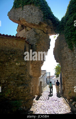 Alentejo, Portugal, 25-Septembre-2007 : un couple en train de marcher par une porte sous un choc des majestueuses ruines antiques à mertola village. Banque D'Images