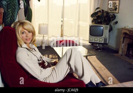 L'actrice française Mireille Darc à la maison dans son appartement dans le 16ème arrondissement de Paris, 1971. Elle porte une tenue conçu par Yves Saint-Laurent. Photo Michael Holtz Banque D'Images