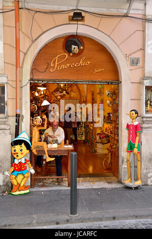 Magasin de vente de souvenirs de Pinocchio à Rome, Italie avec man carving marionnettes Pinocchio Banque D'Images