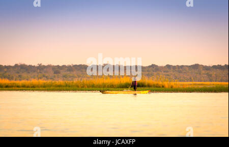 KASANE, BOTSWANA - Juin 2015 - Un homme non identifié des pagaies en bois d'un canot sur la rivière Chobe dans le Parc National de Chobe, Botswana, l'Afrique. Banque D'Images