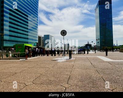 Sur l'heure du déjeuner en semaine de juin, la Défense. Que les travailleurs jusqu'à l'achat de nourriture d'un vert lumineux 'camion alimentaire des Vénézuéliens. Paris, France métropolitaine. Banque D'Images