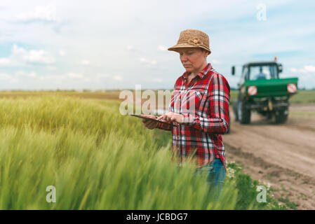Responsable de l'agriculture intelligente, l'utilisation de la technologie moderne dans la production agricole, agricultrice agronome avec tablette numérique à l'aide de l'ordinateur mobile app Banque D'Images