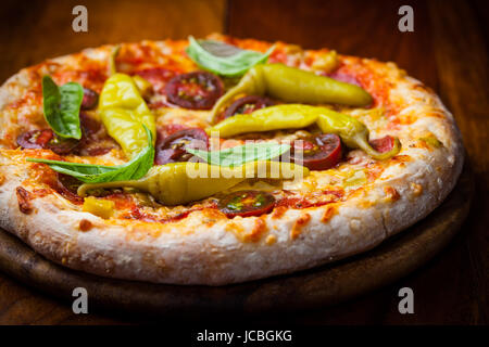 Des pizzas aux tomates séchées, poivrons et basilic Banque D'Images