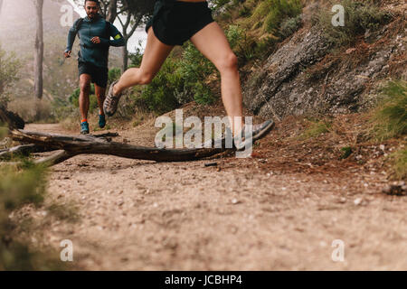 Les jeunes en cours d'exécution sur-pays chemin. Low angle shot de coureurs exerçant sur les chemin de terre. Banque D'Images