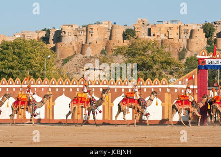 Les chameaux et les cavaliers de l'Indian Border Security Force effectuer en face du fort pendant la Festival du désert à Jaisalmer, Rajasthan, Inde. Banque D'Images