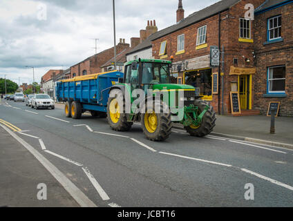 Un modèle agricole John Deere6910 tracteur tirant une grande remorque au centre d'un marché de la ville du Yorkshire Banque D'Images