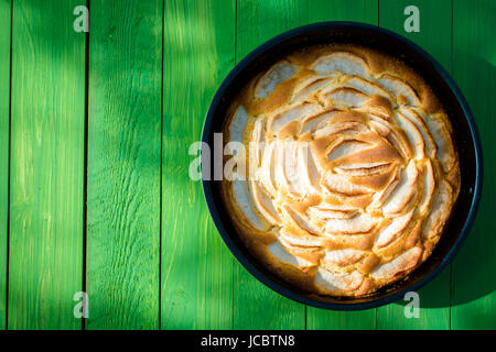 Appétissant du golden apple tart debout prêt à servir sur une table de jardin vert tacheté dans la lumière du soleil pour un pique-nique d'été savoureux Banque D'Images