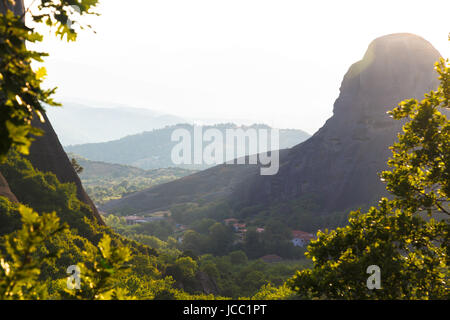 Misty au coucher du soleil du jour chaud sur Moni Agias Varvaras Roussanou rock Météores, Grèce. Banque D'Images