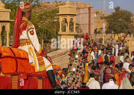 Les chameaux et les cavaliers de l'Indian Border Security Force diriger une procession dans le quartier historique au cours du Festival du désert à Jaisalmer, Inde. Banque D'Images