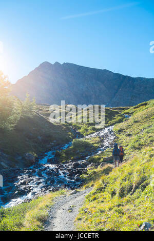 COMBAL, ITALIE - Le 28 août : Les randonneurs montent en chemin creek avec Charmonts pics dans l'arrière-plan. La région est sur une scène de la célèbre tour du Mont Blanc européen. 28 août, 2014 dans Combal. Banque D'Images