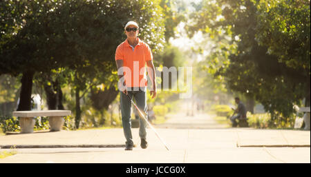 Aveugle hispanique, latino, disability, personne handicapée et de la vie quotidienne. Homme malvoyants avec bâton de marche, traverser la rue Banque D'Images