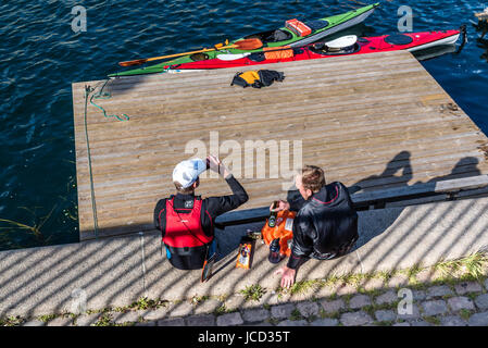 Copenhague, Danemark - 11 août 2016 : les canoéistes se reposant après l'exercice et la consommation de bière assis sur le bord de mer de Copenhague en une journée ensoleillée. Banque D'Images