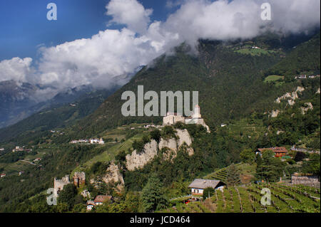 Das Schloss Tirol im Meraner Land in Südtirol, Italien ; die Burg steht auf einem steilen Felsen ; Hänge bewaldete Berge, dans le Tyrol, Wolken château dans le pays de Meran, dans le Tyrol du Sud, Italie, le château se dresse sur un des rochers, pentes boisées, les montagnes dans les nuages Banque D'Images