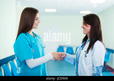 Doctors shaking hands in hospital Banque D'Images