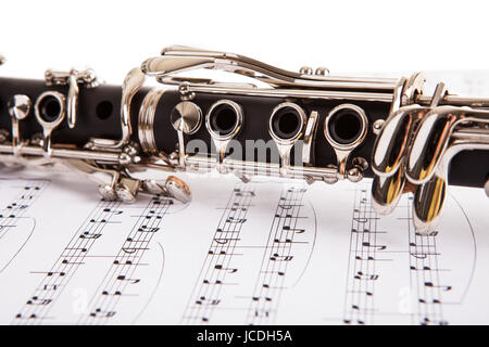 Close-up de clarinette et des notes de musique isolé sur fond blanc Banque D'Images