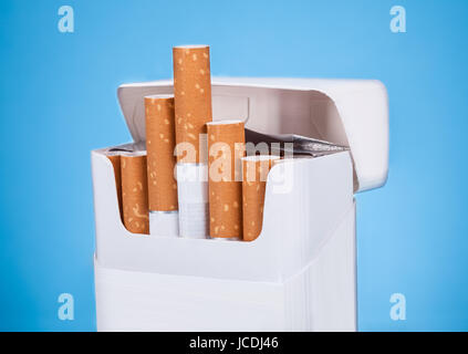 Photo de Cigarettes en paquet sur fond bleu Banque D'Images